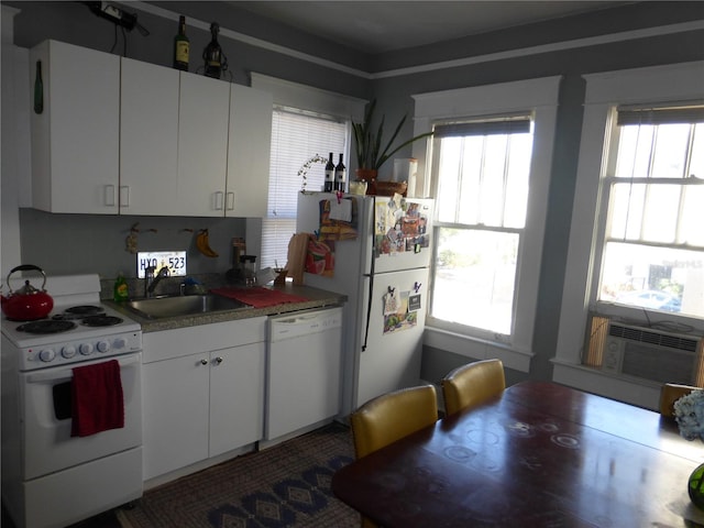 kitchen featuring tasteful backsplash, white appliances, cooling unit, sink, and white cabinetry