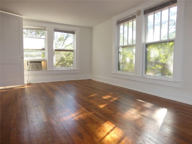 spare room featuring cooling unit and dark wood-type flooring