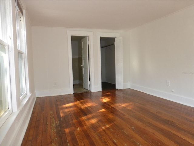 unfurnished bedroom featuring connected bathroom and dark hardwood / wood-style floors