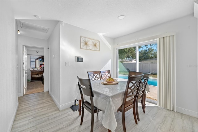 dining room featuring a textured ceiling and light hardwood / wood-style flooring