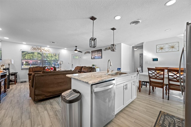 kitchen with white cabinetry, sink, decorative light fixtures, a center island with sink, and appliances with stainless steel finishes