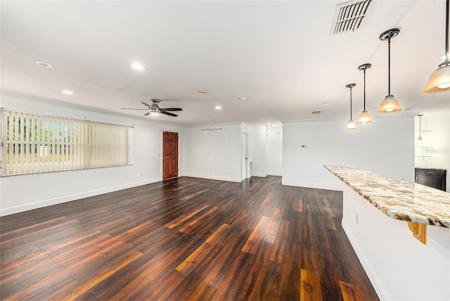 unfurnished living room with ceiling fan, dark wood-type flooring, and ornamental molding