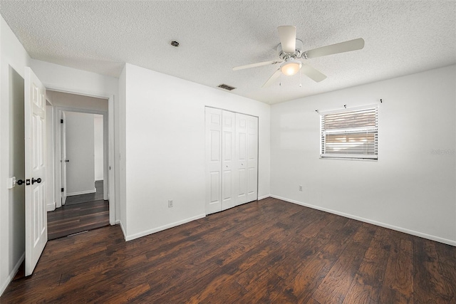 unfurnished bedroom featuring a textured ceiling, a closet, dark hardwood / wood-style floors, and ceiling fan