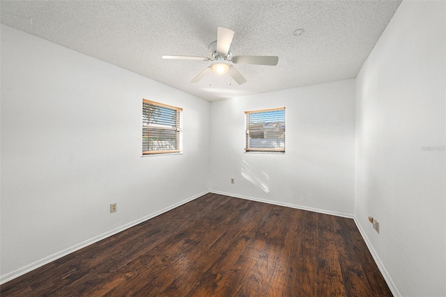 empty room featuring a textured ceiling, ceiling fan, and dark wood-type flooring