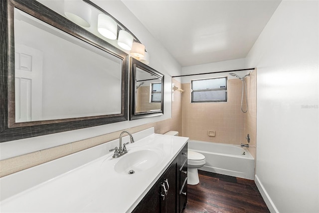 full bathroom with hardwood / wood-style floors, tiled shower / bath combo, toilet, and vanity