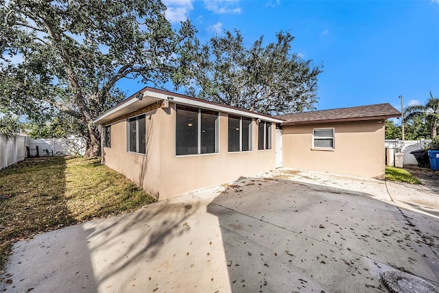 rear view of property featuring a patio area and a lawn