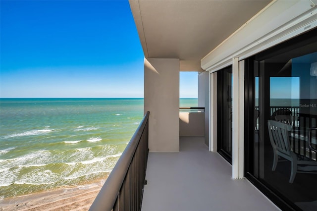 balcony with a water view and a beach view