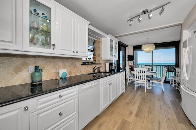 kitchen featuring a wealth of natural light, sink, white cabinets, and white appliances