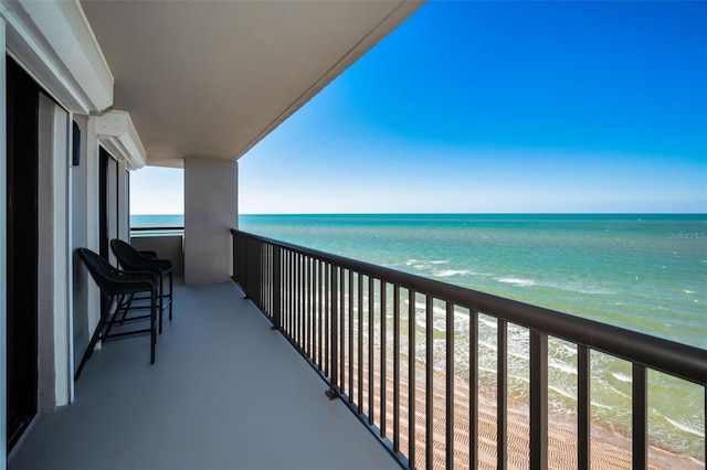 balcony featuring a water view and a view of the beach