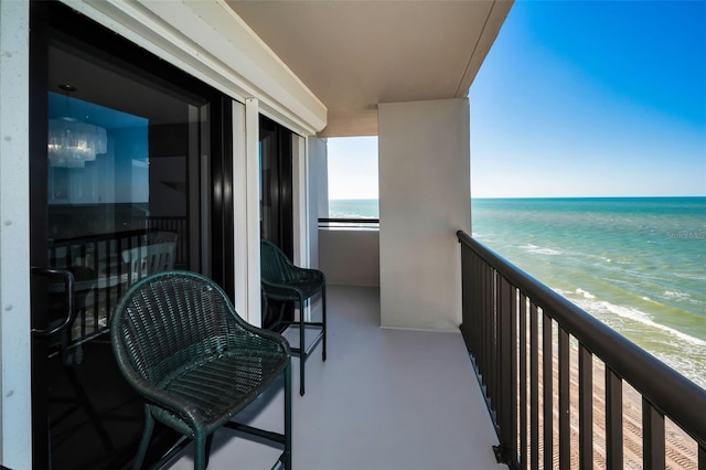 balcony featuring a water view and a view of the beach