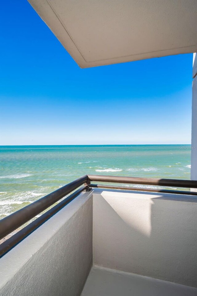 balcony featuring a beach view and a water view