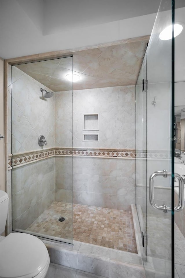 bathroom with an enclosed shower and toilet