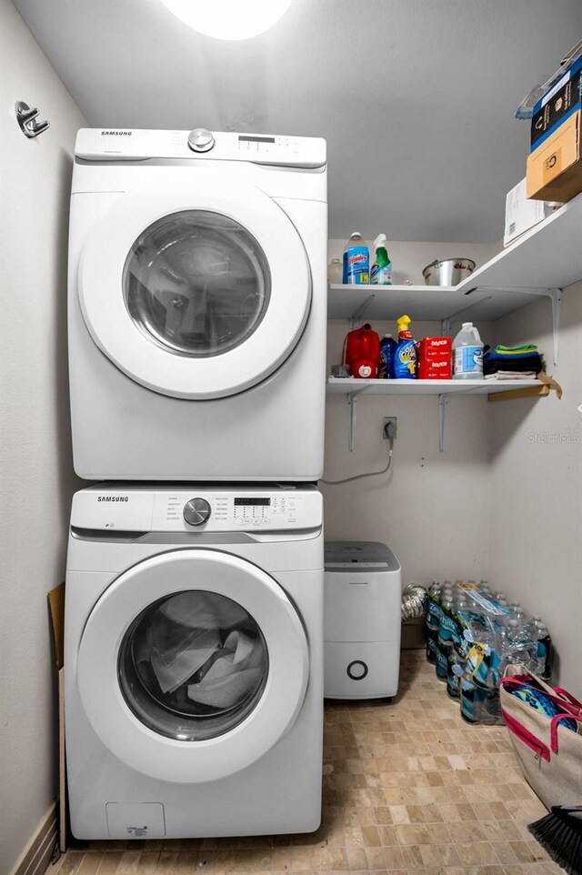 clothes washing area featuring stacked washer and clothes dryer