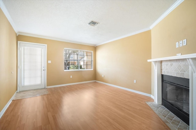 unfurnished living room with a fireplace, a textured ceiling, light hardwood / wood-style flooring, and ornamental molding