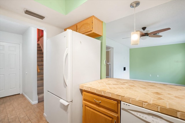 kitchen featuring ceiling fan, tile counters, pendant lighting, and white appliances