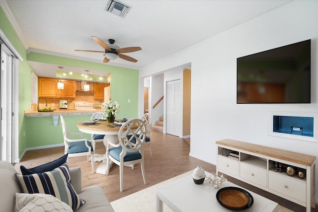 living room with ceiling fan, ornamental molding, and light hardwood / wood-style flooring