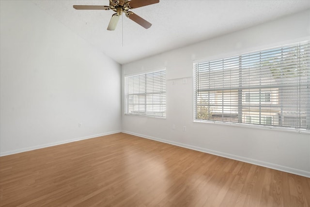 empty room featuring vaulted ceiling, ceiling fan, wood-type flooring, and a textured ceiling