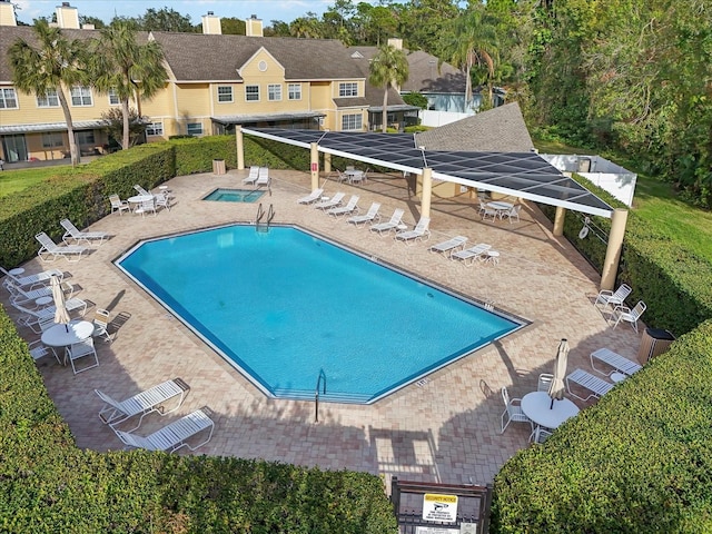 view of swimming pool featuring a community hot tub and a patio area