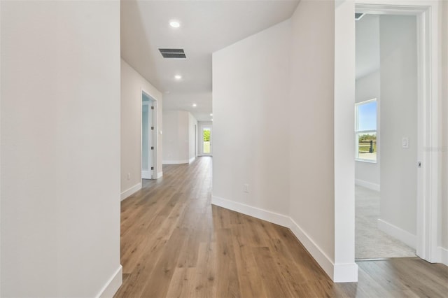 hallway with light hardwood / wood-style floors