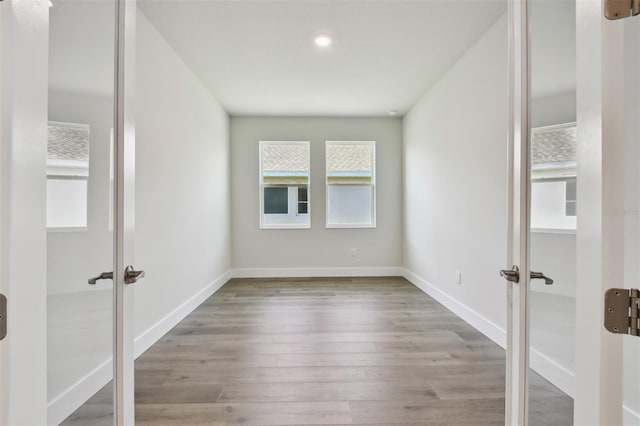 spare room with french doors and light wood-type flooring