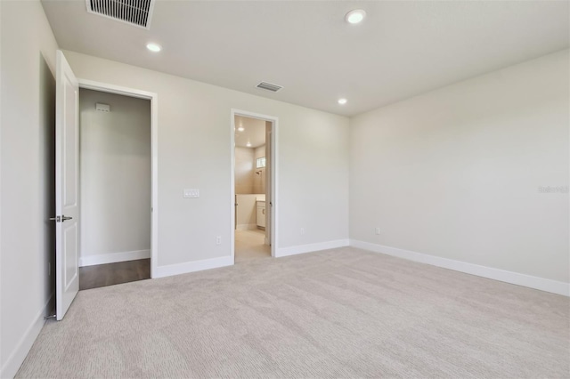 unfurnished bedroom with light colored carpet and ensuite bathroom