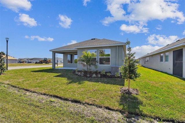 exterior space with central AC, a carport, and a front yard