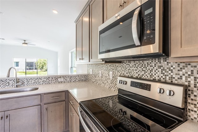 475 Winwood Ct, Port Charlotte, FL 33954 - kitchen featuring stainless steel appliances, a sink, decorative backsplash, lofted ceiling, and light countertops