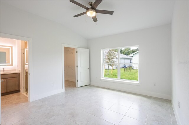 475 Winwood Ct, Port Charlotte, FL 33954 - unfurnished bedroom with a sink, vaulted ceiling, a walk in closet, baseboards, and light tile patterned floors