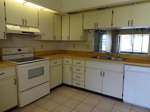 kitchen featuring light tile patterned flooring, white appliances, backsplash, and sink