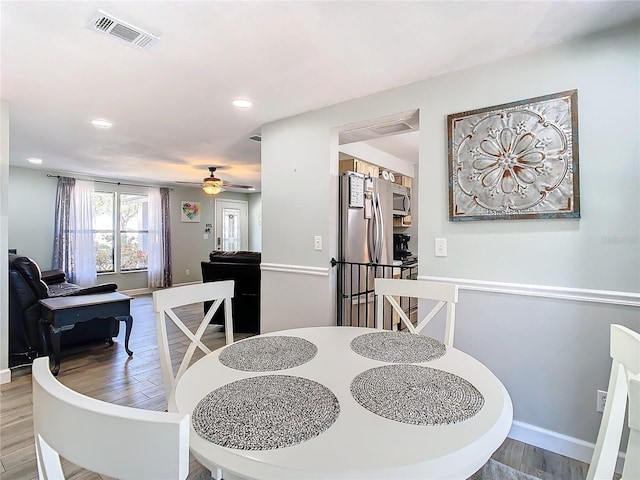 dining area with hardwood / wood-style floors and ceiling fan