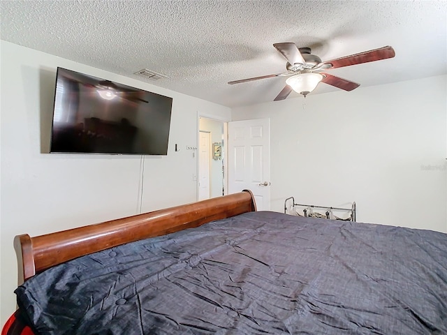 bedroom featuring ceiling fan and a textured ceiling