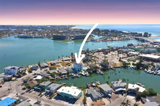 aerial view at dusk featuring a water view