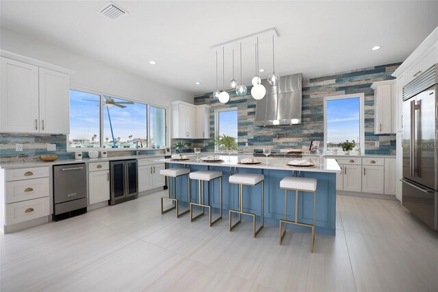 kitchen with a center island, white cabinets, beverage cooler, and stainless steel built in refrigerator