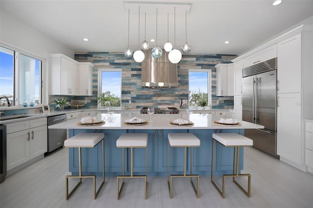 kitchen featuring appliances with stainless steel finishes, island range hood, and a kitchen island