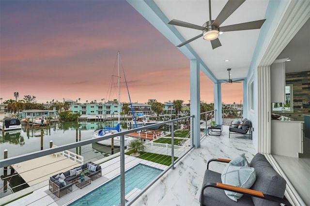 balcony at dusk with ceiling fan and a water view