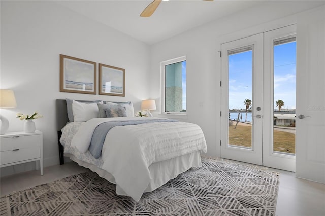 bedroom with ceiling fan, a water view, access to outside, and french doors