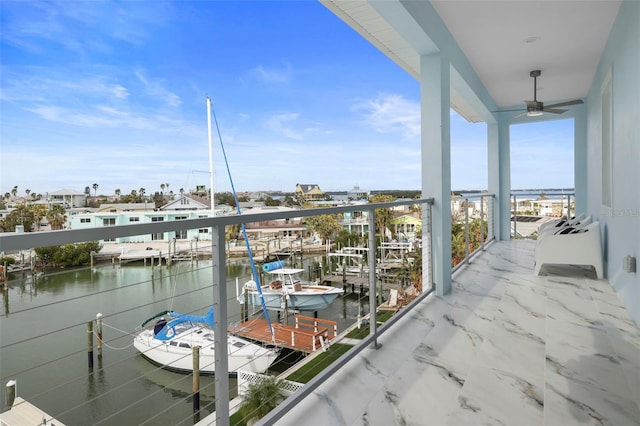 balcony with ceiling fan and a water view