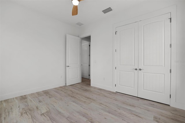 unfurnished bedroom with light wood-type flooring, a closet, and ceiling fan