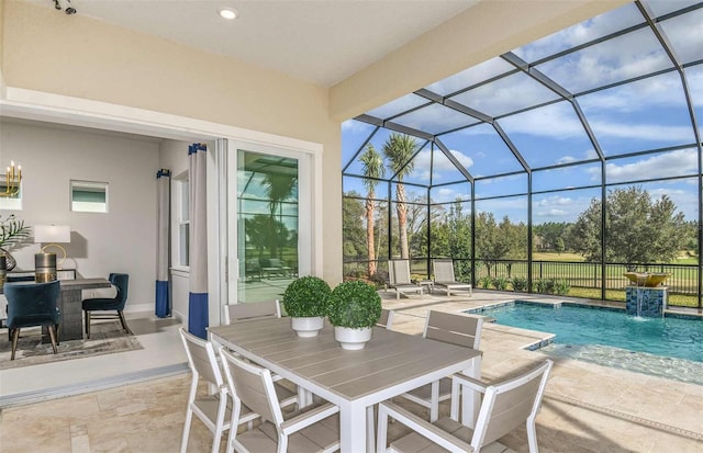 view of pool with pool water feature, glass enclosure, and a patio