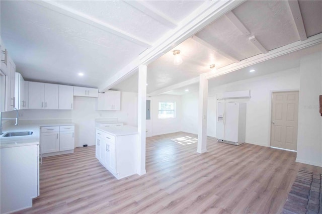 kitchen featuring electric panel, white cabinets, sink, white fridge with ice dispenser, and light hardwood / wood-style floors