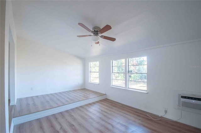 unfurnished room with ceiling fan, light hardwood / wood-style flooring, and a wall mounted air conditioner