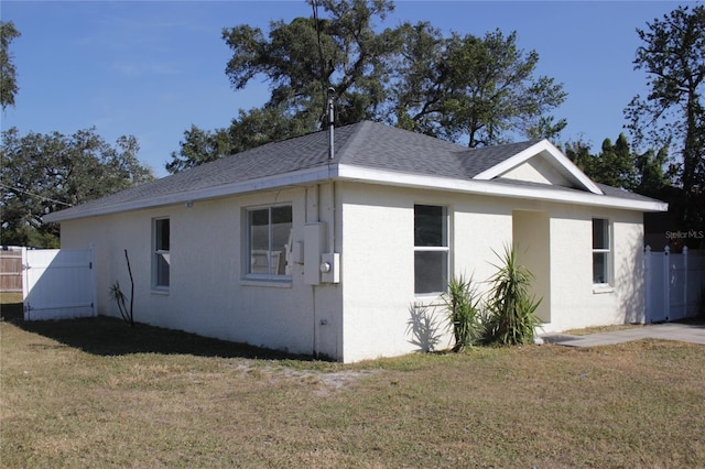 1302 E Annie St, Tampa, FL 33612 - view of property exterior featuring stucco siding, roof with shingles, and a gate