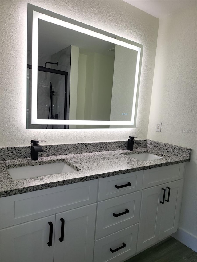 bathroom featuring vanity, wood-type flooring, and a shower with shower door