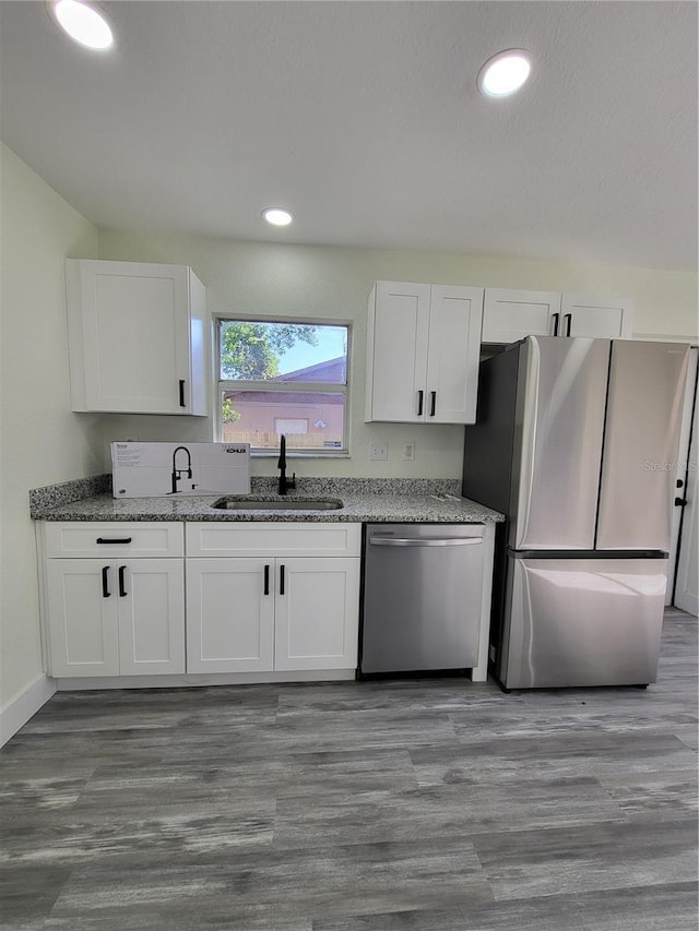 kitchen featuring sink, white cabinetry, stainless steel appliances, and stone counters