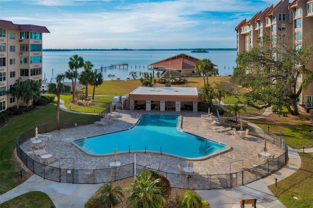 view of pool featuring a water view and a patio