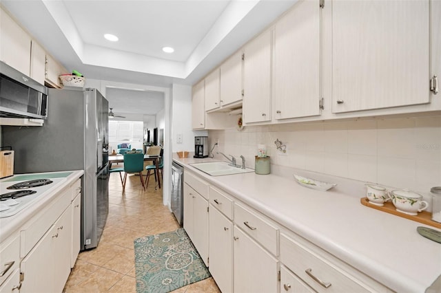 kitchen featuring ceiling fan, white cabinetry, sink, and light tile patterned floors