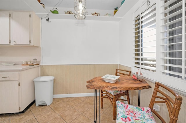 tiled dining area featuring wooden walls