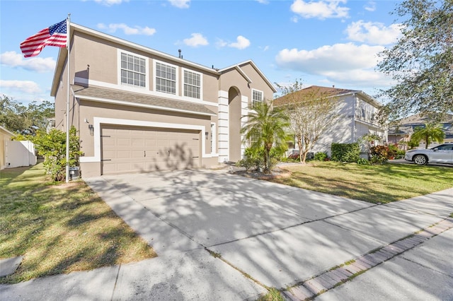 view of property featuring a garage and a front lawn