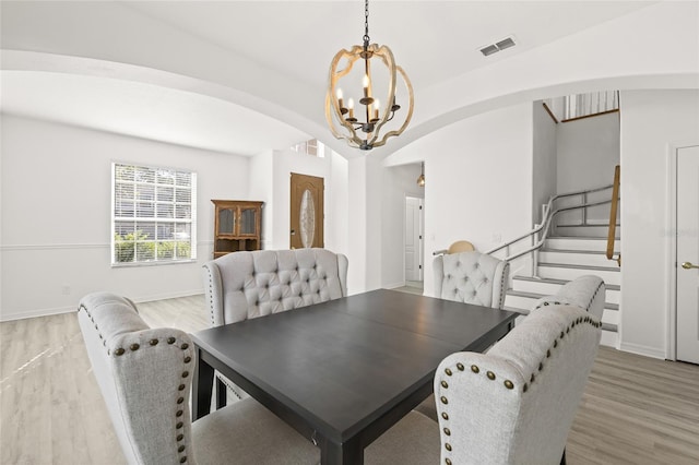 dining room with wood-type flooring and a notable chandelier