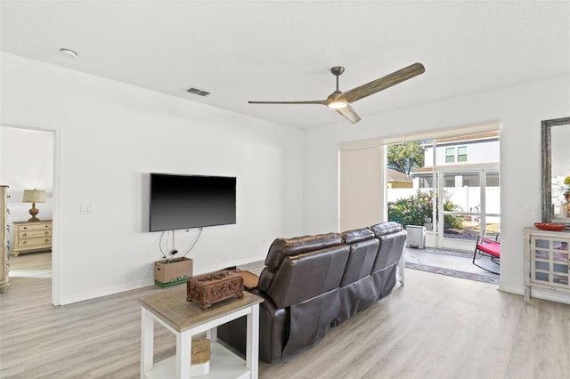 living room featuring ceiling fan and light hardwood / wood-style floors